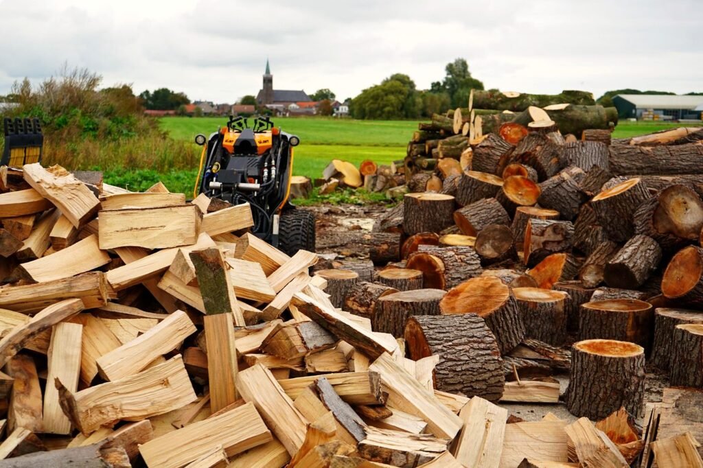 Gekloofd haardhout en stammen op de werf met de dorpskerk op de achtergrond